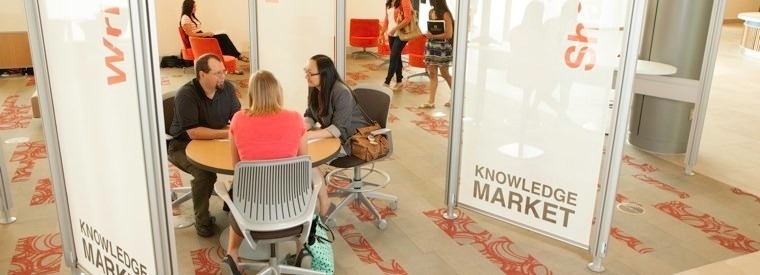 Consultants sitting at a table in the Mary Idema Pew Knowledge Market